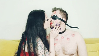 Kissing bizarre. Dominatrix kisses her beloved slave and leaves lipstick marks on his body